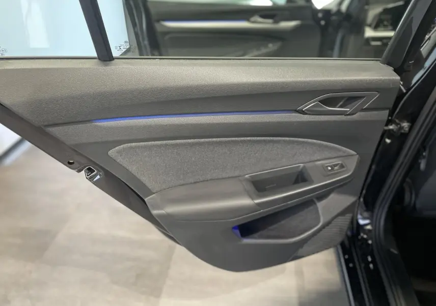 Porte arrière gauche noire de Volkswagen Golf 2024 avec éclairage d'ambiance bleu et garniture tissu et plastique.