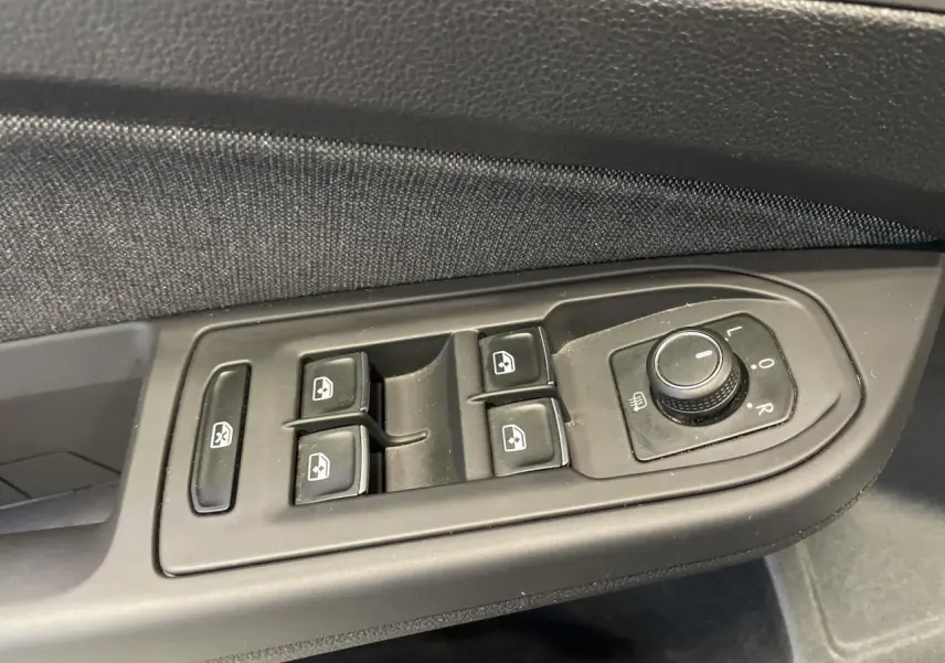 Commande des vitres électriques et réglage des rétroviseurs côté conducteur de la Volkswagen Golf noire 2024 Style.