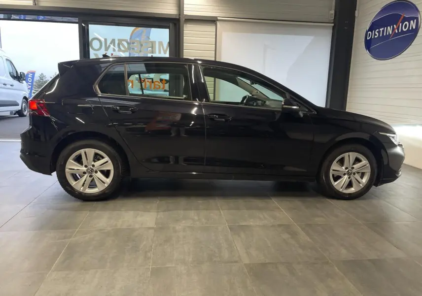 Profil latéral droit d'une Volkswagen Golf noire 2024, avec jantes alliage 17 pouces et poignées couleur carrosserie.