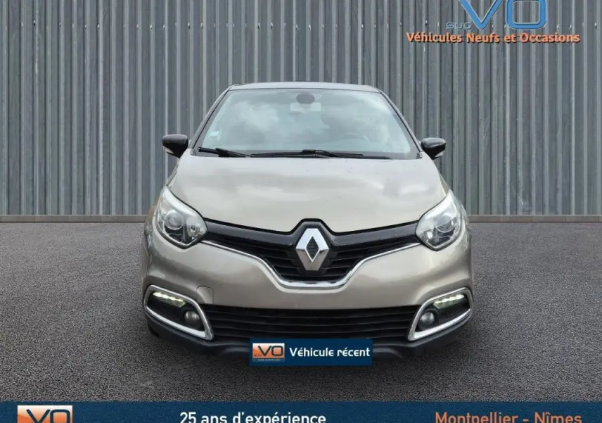 Vue frontale d'un Renault Captur gris 2014 avec feux diurnes LED et calandre noire distinctive.