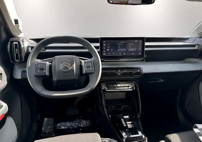 Tableau de bord et volant noir de Citroën C3 Aircross 2026 vus de face avec écran tactile central allumé.
