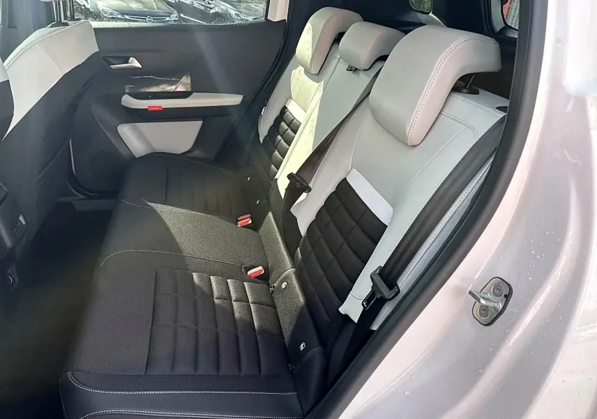 Vue côté droit sur l'intérieur arrière du Citroën C3 Aircross blanc, sièges bicolores noir et beige avec appuie-têtes.
