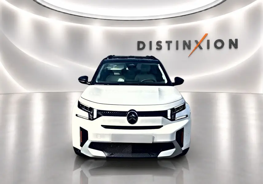 Vue frontale d'un Citroën C3 Aircross blanc avec toit noir, calandre noire et éclairage LED distinctif.