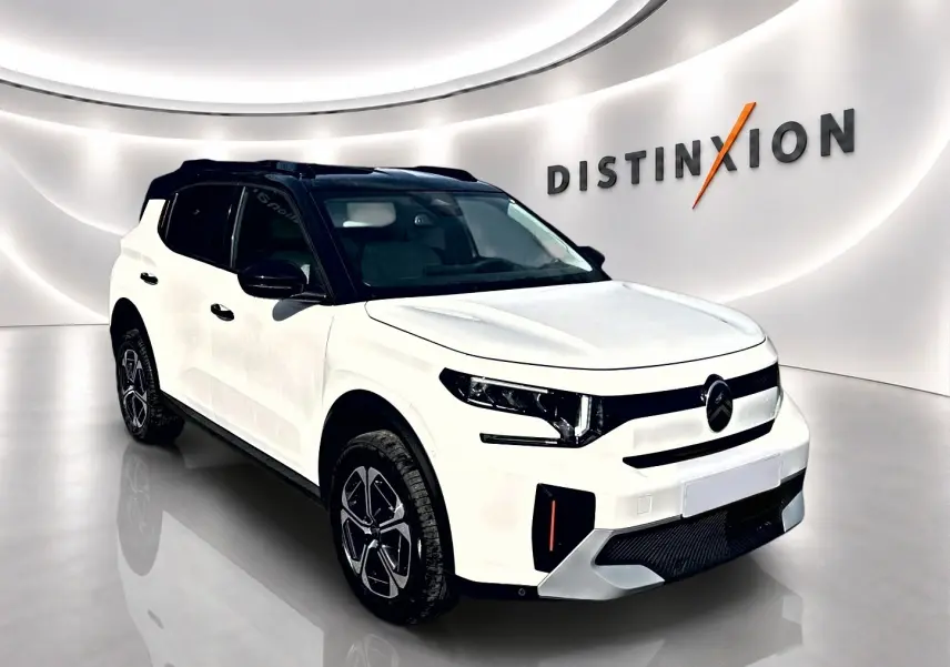 Citroën C3 Aircross blanc vue 3/4 avant droit avec toit noir et jantes alu dans showroom lumineux.