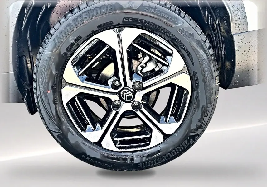 Gros plan sur la jante alu noire et argentée d'une Citroën C3 Aircross blanche, vue côté roue avant droite.