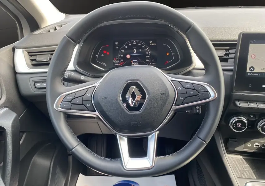 Vue rapprochée du volant noir du Renault Captur TCe 90 Techno 2024 avec tableau de bord numérique et console centrale.