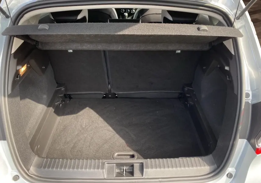 Coffre ouvert du Renault Captur TCe 90 Techno gris Highland, montrant un espace de rangement propre et spacieux.