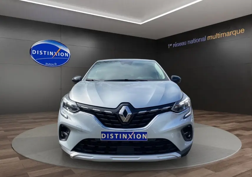 Vue frontale du Renault Captur TCE 90 TECHNO gris Highland, avec calandre noire et logo Renault bien visible.