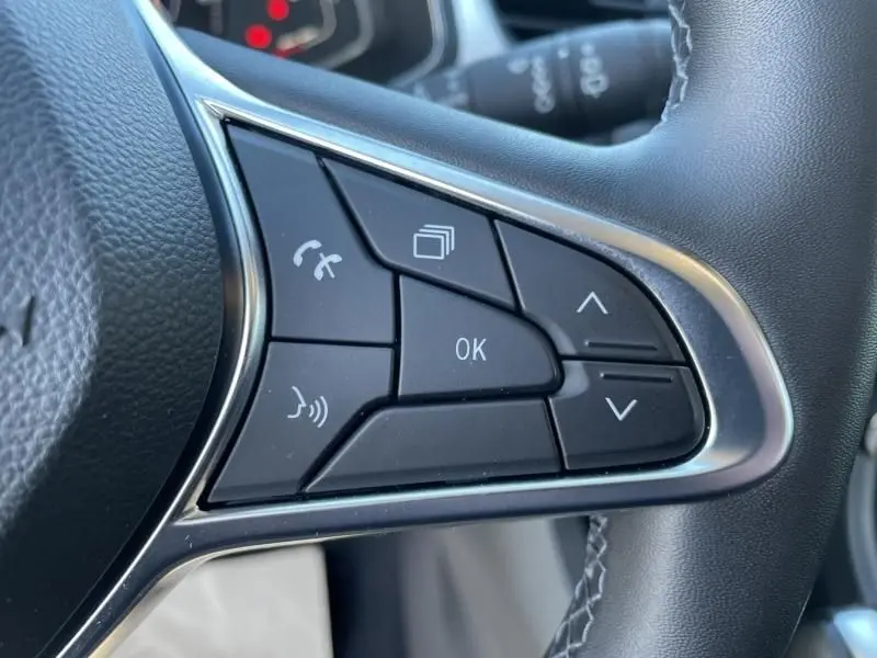 Gros plan sur les commandes multifonctions à droite du volant du Renault Captur gris métal 2022 hybride.