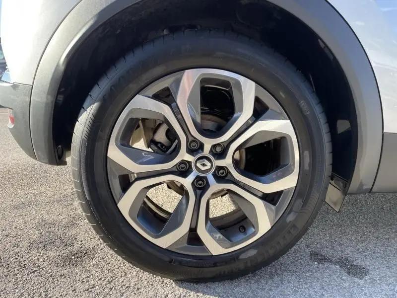 Vue rapprochée de la roue arrière côté gauche d'un Renault Captur gris métal 2022 avec passage de roue noir.