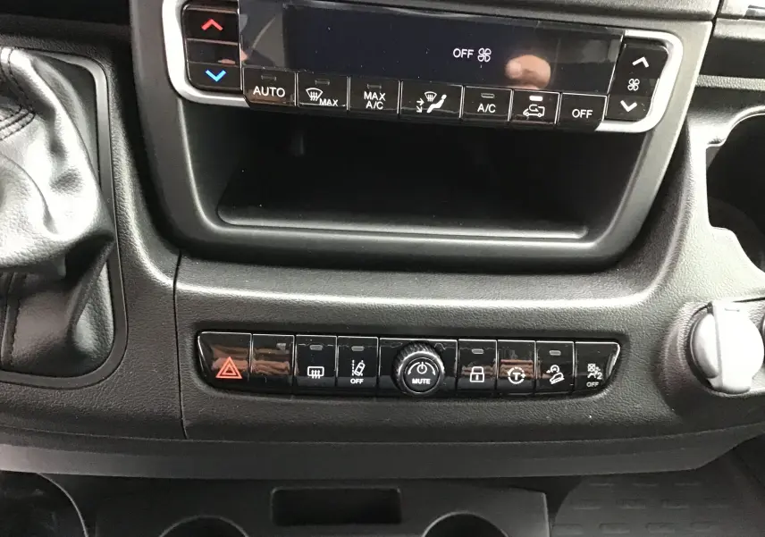 Vue rapprochée de la console centrale du Peugeot Boxer Fourgon blanc 2025, mettant en valeur les commandes climatisation et fonctions avancées.