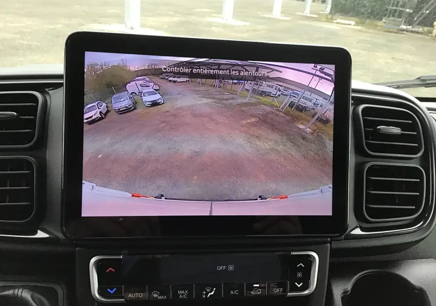 Écran intérieur du Peugeot Boxer Fourgon blanc montrant la caméra de recul avec vue arrière dégagée sur un parking.