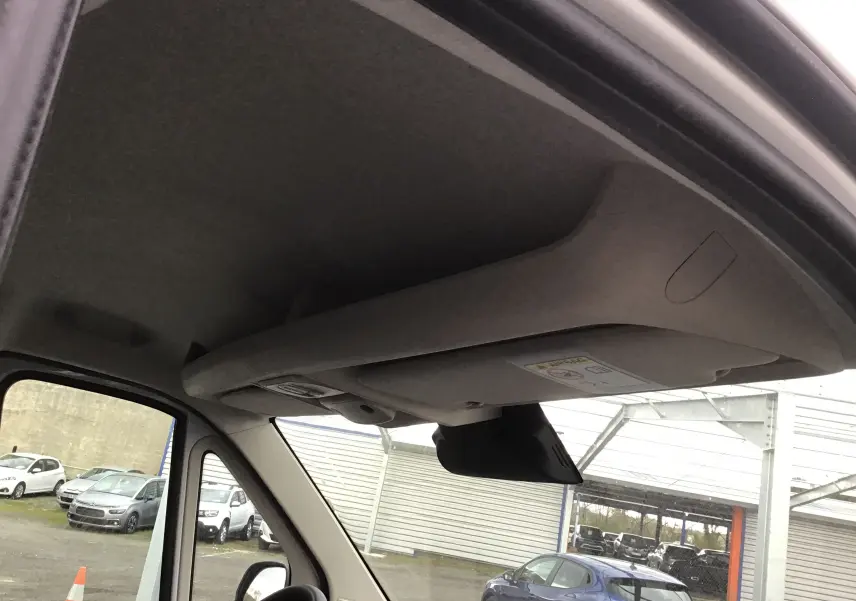 Vue intérieure du plafond et pare-soleil du Peugeot Boxer Fourgon blanc, côté conducteur, avec rétroviseur visible.