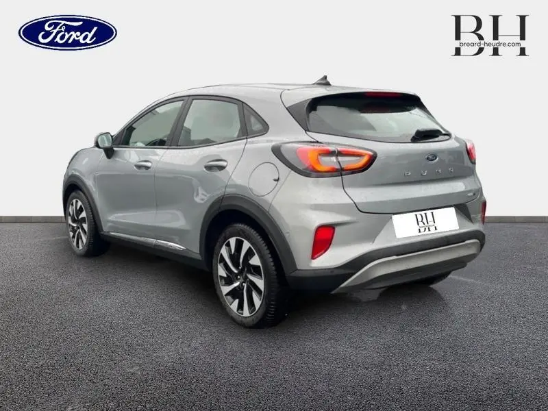 Vue 3/4 arrière droite du Ford Puma 2023 gris Solar métallisé avec feux arrière allumés et jantes alliage distinctives.