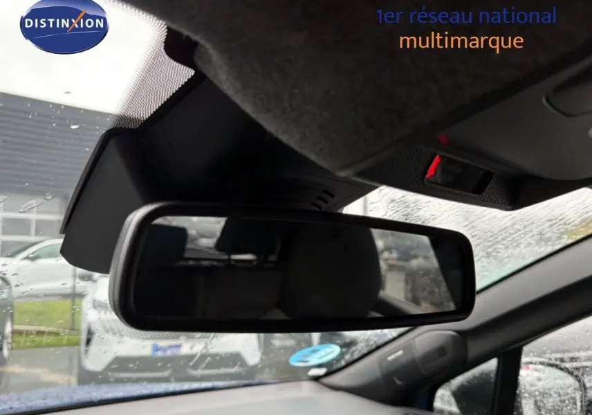 Rétroviseur intérieur du Renault Captur bleu Iron Metal 2025, avec vue partielle sur l’habitacle et l’extérieur sous la pluie.
