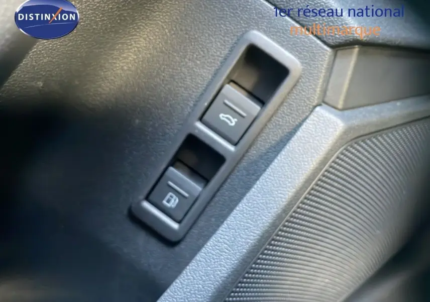 Gros plan sur les boutons d'ouverture du coffre et de la trappe à carburant dans l'habitacle d'une Audi A3 Sportback noire.