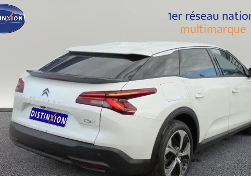 Vue 3/4 arrière droite d'une Citroën C5 X blanche métallisée avec feux arrière LED et jantes bi-ton.