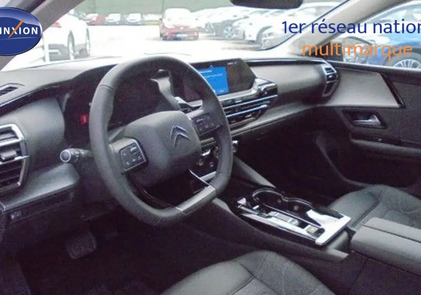 Intérieur du Citroën C5 X 2023 vu côté conducteur, avec tableau de bord moderne et sellerie cuir noir.