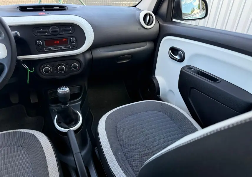 Intérieur avant droit de la Renault Twingo III 2021, tableau de bord noir et blanc avec levier de vitesse manuel.