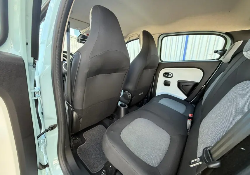 Vue intérieure arrière côté gauche d'une Renault Twingo III bleu dragée, sièges tissu bicolore gris et noir.