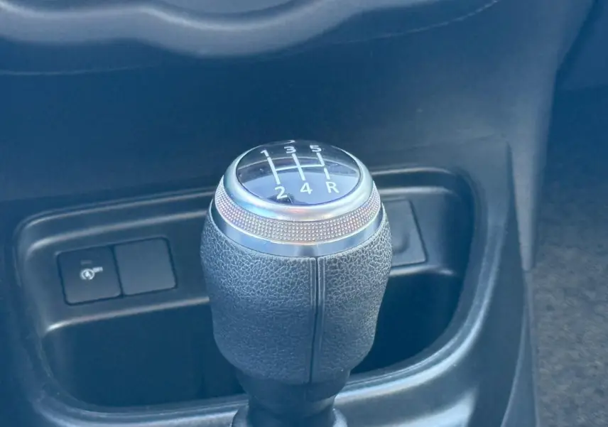 Le levier de vitesses manuel de la Renault Twingo III bleu dragée, vu en gros plan dans l'habitacle.