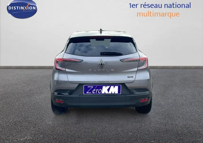 Vue arrière d'un Renault Captur gris Cassiopée métal avec toit noir, affichant son logo et feux LED distinctifs.