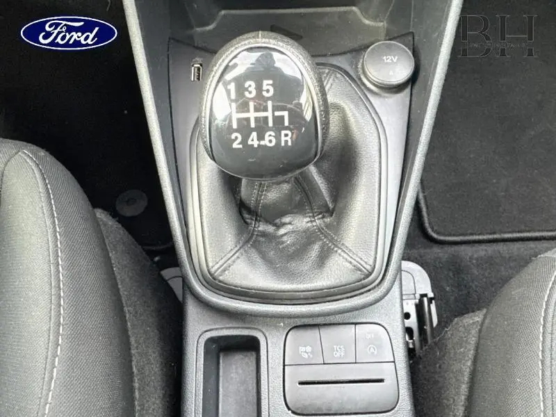 Vue rapprochée du levier de vitesses manuel noir de la Ford Fiesta gris lunaire, entouré des sièges et commandes centrales.