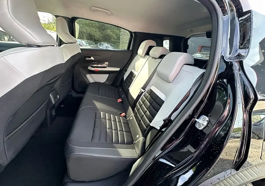 Vue intérieure arrière côté droit du Citroën C3 Aircross noir 2026 avec sièges bicolores noir et clair.