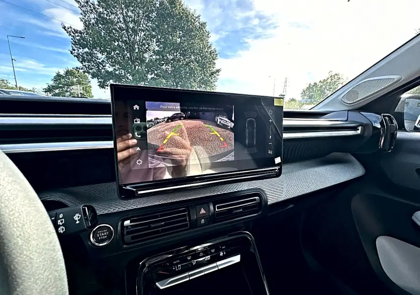 Vue intérieure de face du tableau de bord de la Citroën C3 Aircross 2026 avec écran tactile affichant la caméra de recul.