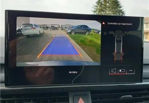 Affichage de la caméra de recul de l'Audi A4 Avant Business gris Terra, avec guidage de trajectoire visible à l'écran.