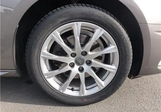 Gros plan sur la roue avant droite de l'Audi A4 Avant Business 30 TDI gris Terra avec jante alliage 17 pouces.