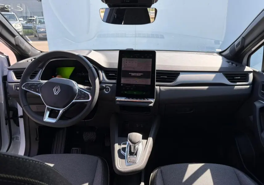 Intérieur avant du Renault Symbioz blanc nacré 2025 avec tableau de bord numérique et écran tactile vertical central.