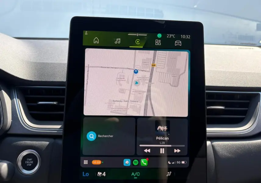 Écran tactile central affichant la navigation et la musique dans l'habitacle du Renault Symbioz blanc nacré.
