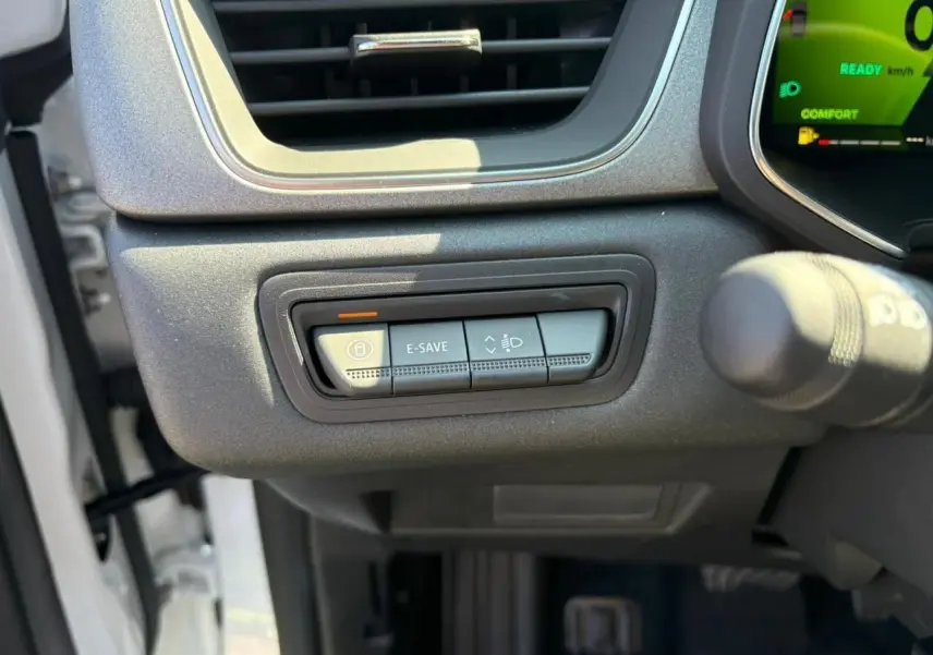 Gros plan sur les commandes sous la ventilation côté gauche du tableau de bord du Renault Symbioz blanc nacré 2025.