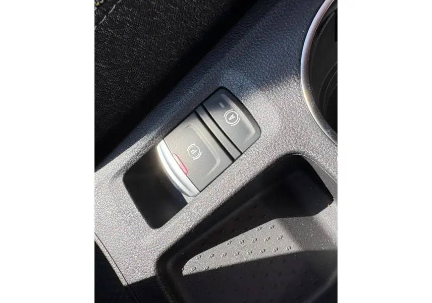 Gros plan sur la console centrale noire du Renault Symbioz 2025, montrant les commandes du frein de parking électrique et Auto-Hold.