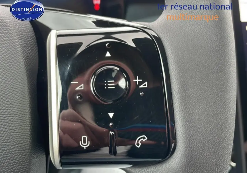 Gros plan sur les commandes multifonctions noires du volant du Citroën C5 Aircross gris platinium, version hybride 2026.