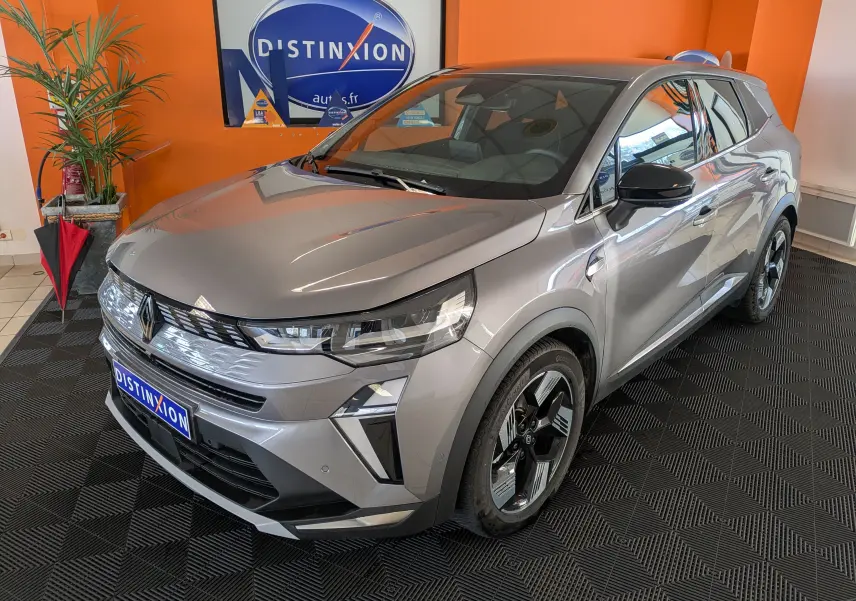 Profil droit du Renault SYMBIOZ gris cassiopée métal 2025 en hybride essence, roues alliage distinctives, intérieur showroom.