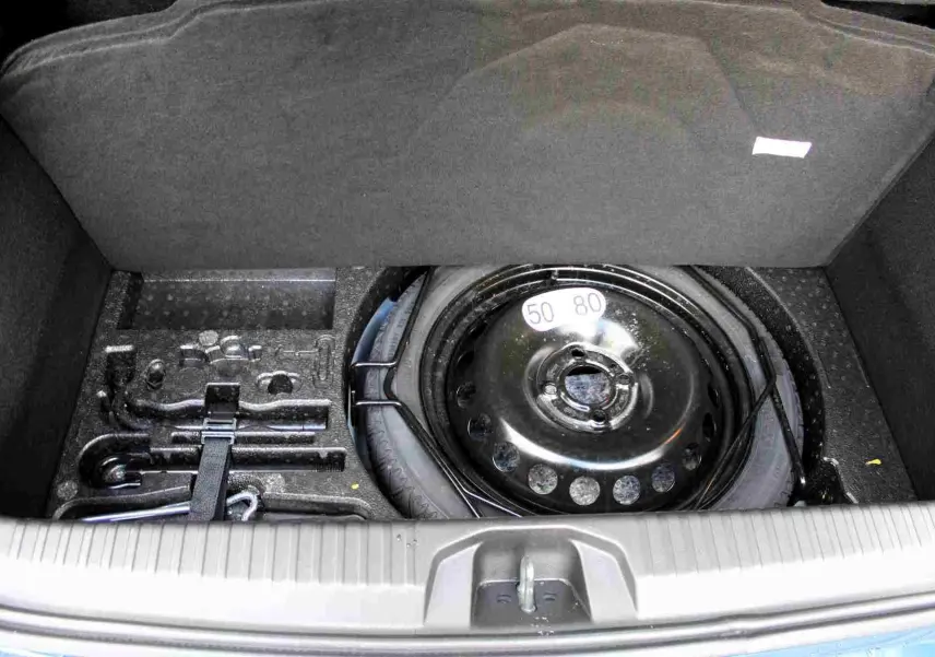 Coffre ouvert vu de l'arrière d'une Renault Clio 2025 bleu iron metal, montrant l'espace de chargement vide.
