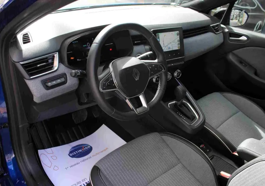 Coffre ouvert d’une Renault Clio bleu Iron Metal 2025, montrant la roue de secours et les outils de bord.