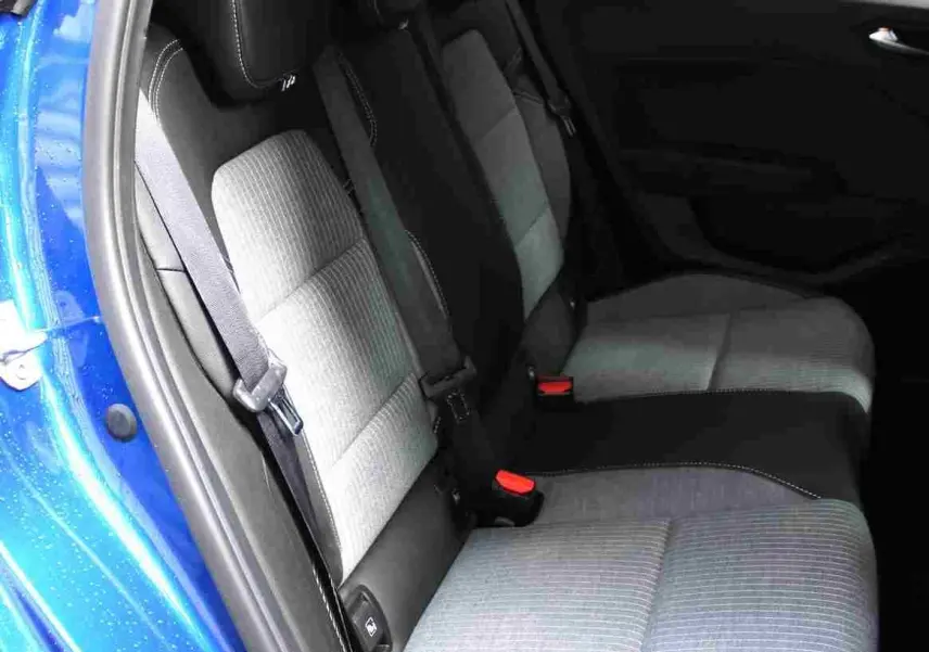 Vue intérieure côté arrière droit de la Renault Clio bleu Iron Metal, montrant les sièges arrière bi-matière gris clair et noir.