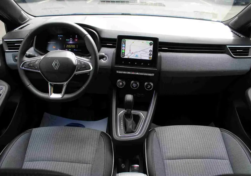 Vue intérieure côté gauche de la Renault Clio 2025 bleu iron metal, montrant les sièges avant gris et noir avec surpiqûres blanches.