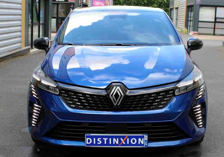 Renault Clio V E-Tech hybride bleu Iron Metal vue 3/4 avant avec feux LED et jantes alliage distinctives.