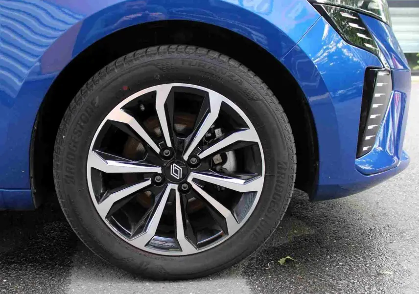 Vue frontale d'une Renault Clio 2025 bleu iron metal avec calandre noire et feux LED verticaux allumés.