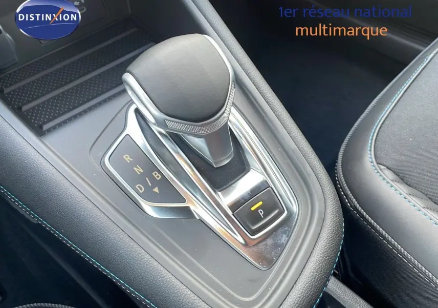 Le levier de vitesses automatique du Renault Captur E-Tech hybride, avec coutures bleues sur la console noire.