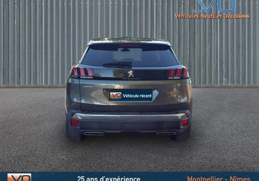 Vue arrière d'un Peugeot 3008 gris foncé de 2018 avec feux arrière caractéristiques et double sortie d'échappement.