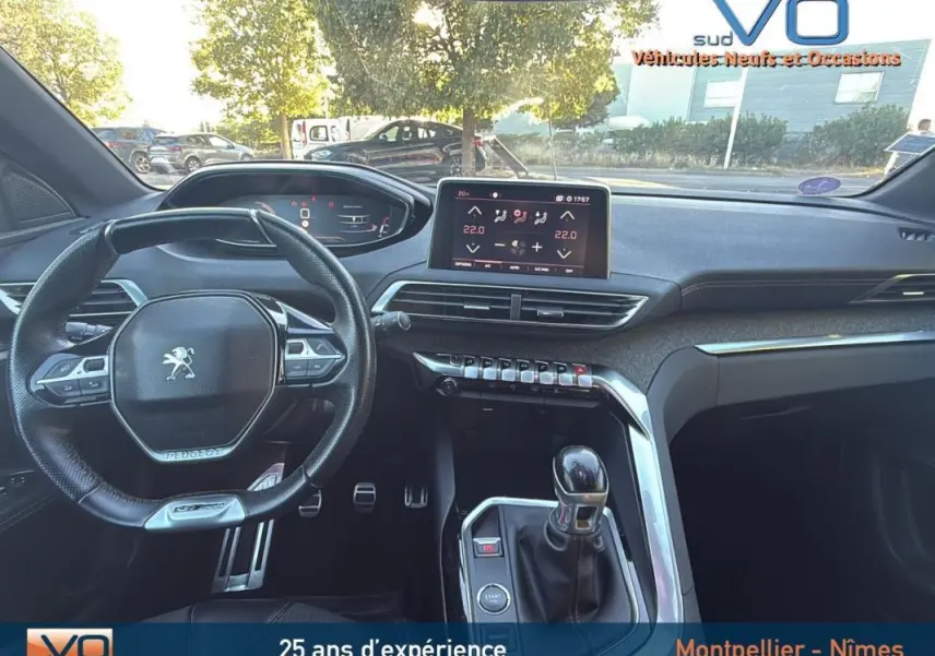 Intérieur du Peugeot 3008 gris foncé, vue du poste de conduite avec volant cuir, écran tactile et levier de vitesses manuel.