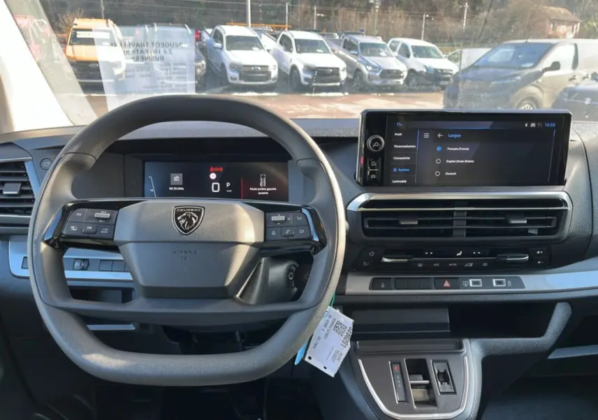 Vue intérieure frontale du tableau de bord du Peugeot Traveller gris acier 2025 avec écran tactile et volant multifonctions.