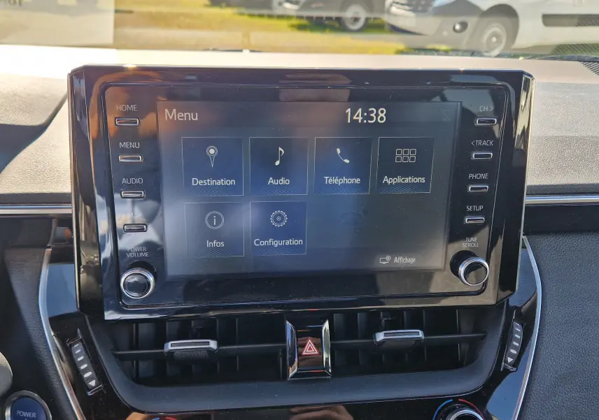 Vue rapprochée de l’écran tactile central noir de la Toyota Corolla Hybride 122h Design 2019, affichant le menu principal.