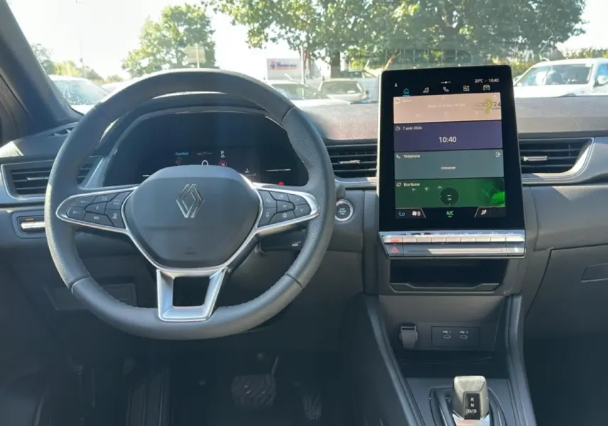 Intérieur Renault Captur 2026 vu de face, volant multifonction et grand écran tactile central.