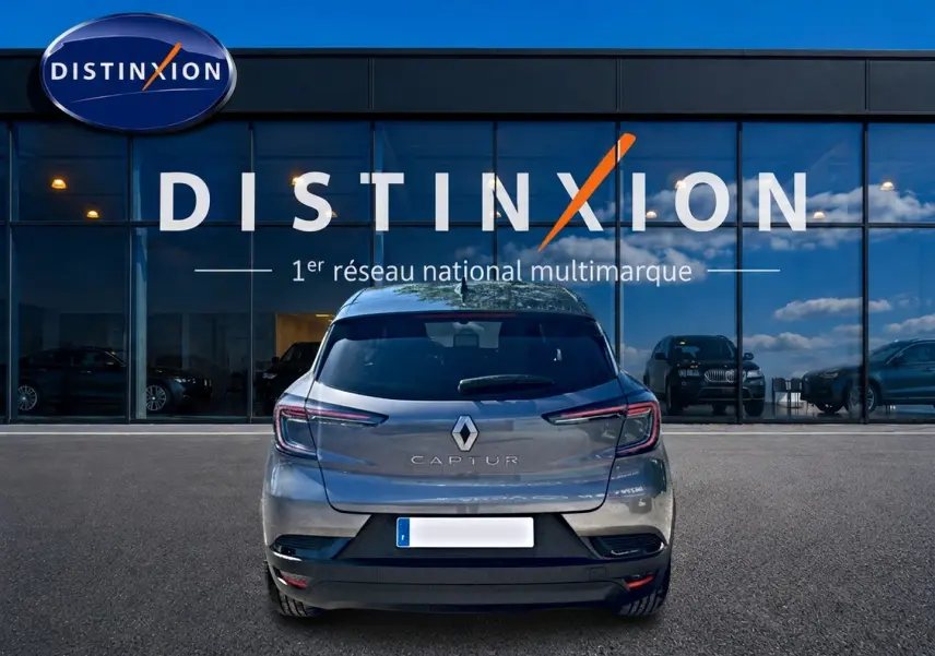 Vue arrière d'un Renault Captur gris cassiopée 2026, avec feux LED et logo distinctif sur fond de vitrine Distinxion.